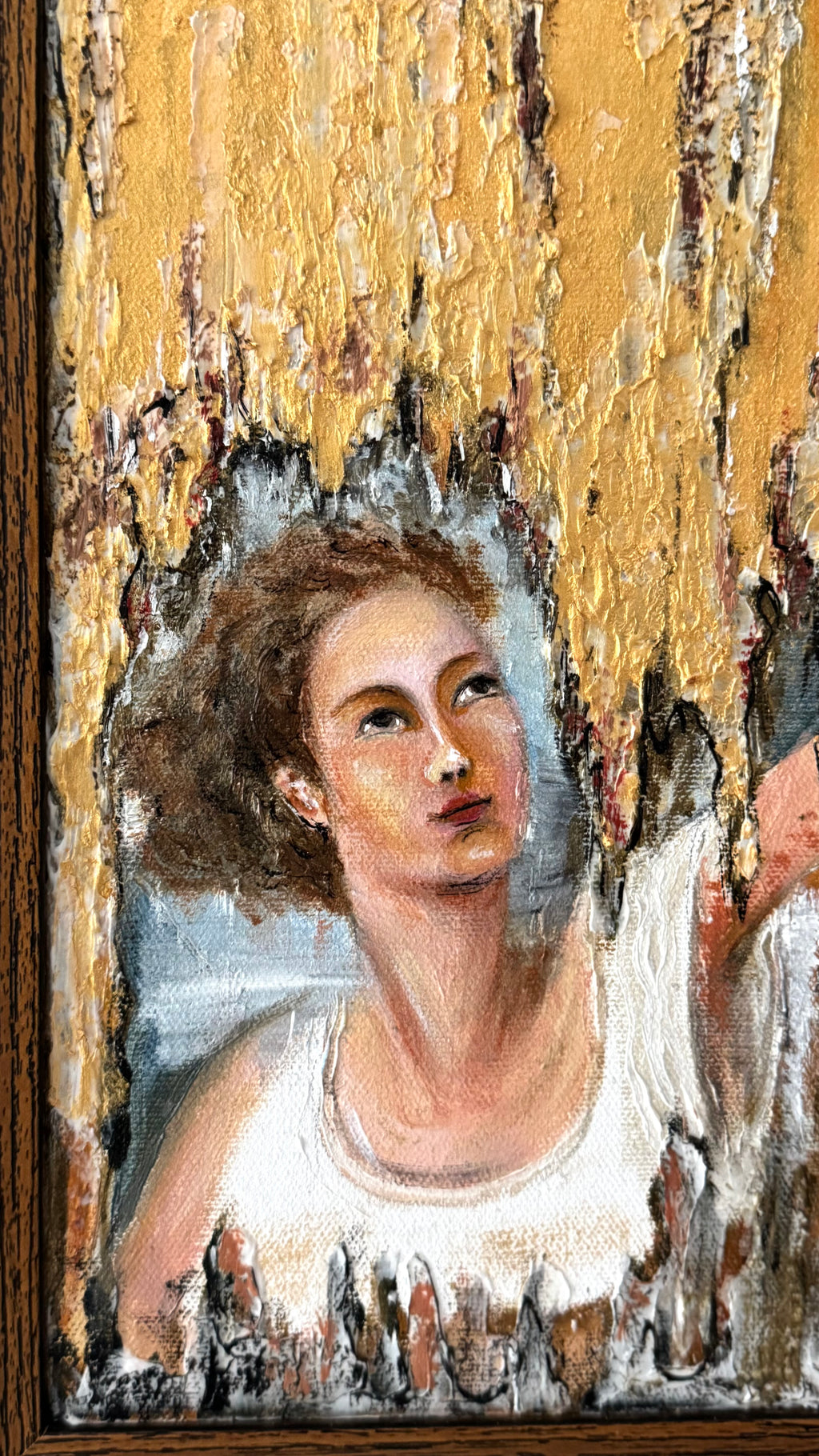 Close-up of framed gold textured painting with classical portrait detail, inspired by Italian masters, showing rich texture and warm golden tones
