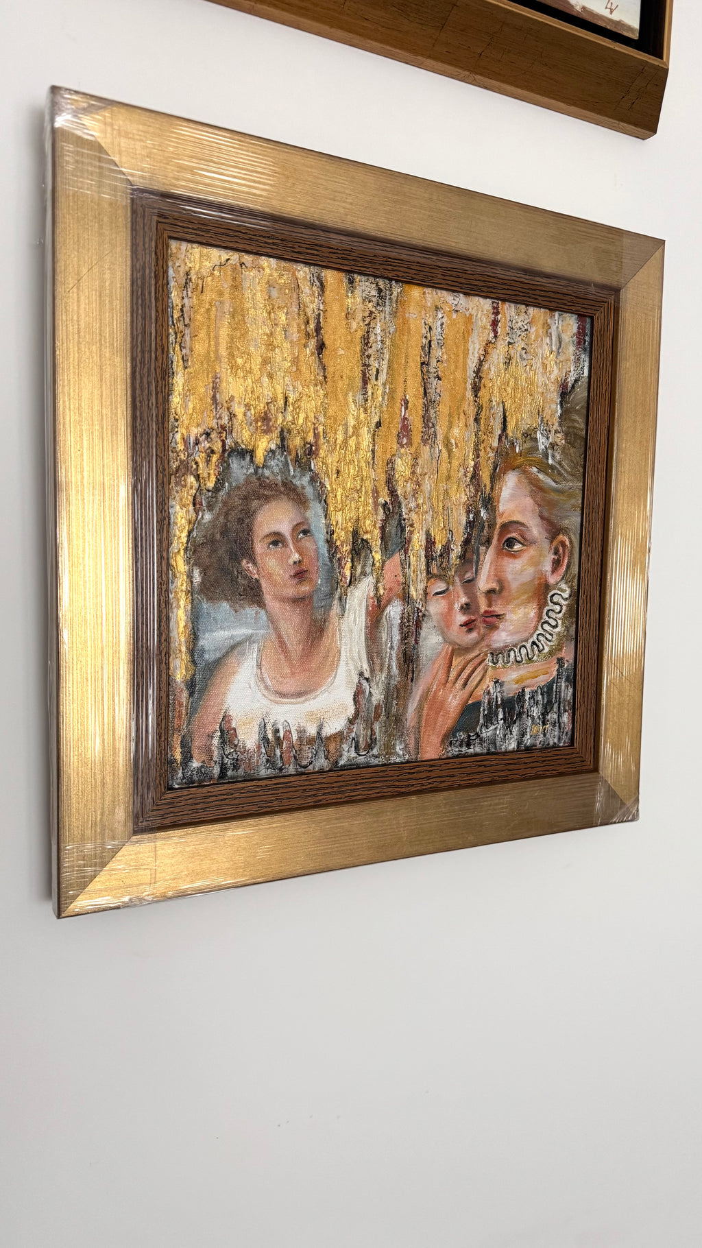 Framed gold textured painting in angled view on wall, elegant contemporary European art inspired by Italian masters with rich golden tones